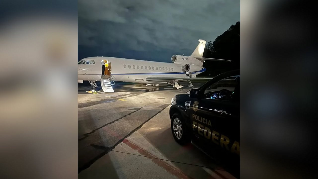 Jato particular com viatura da Polícia Federal em cenário noturno.